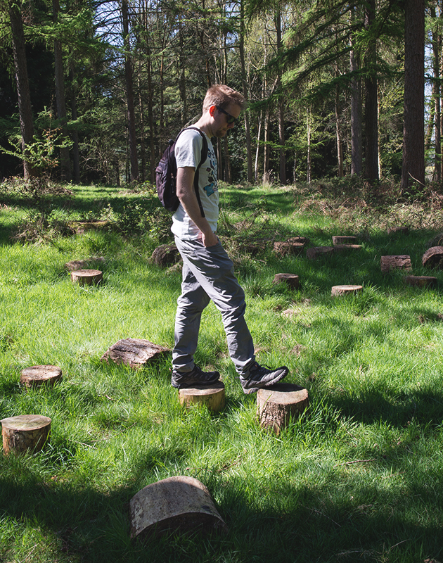 Man stepping on tree stumps