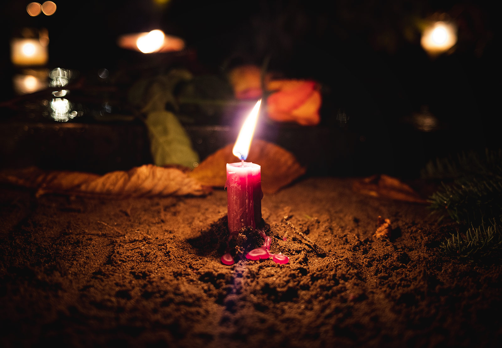Red candle in the soil