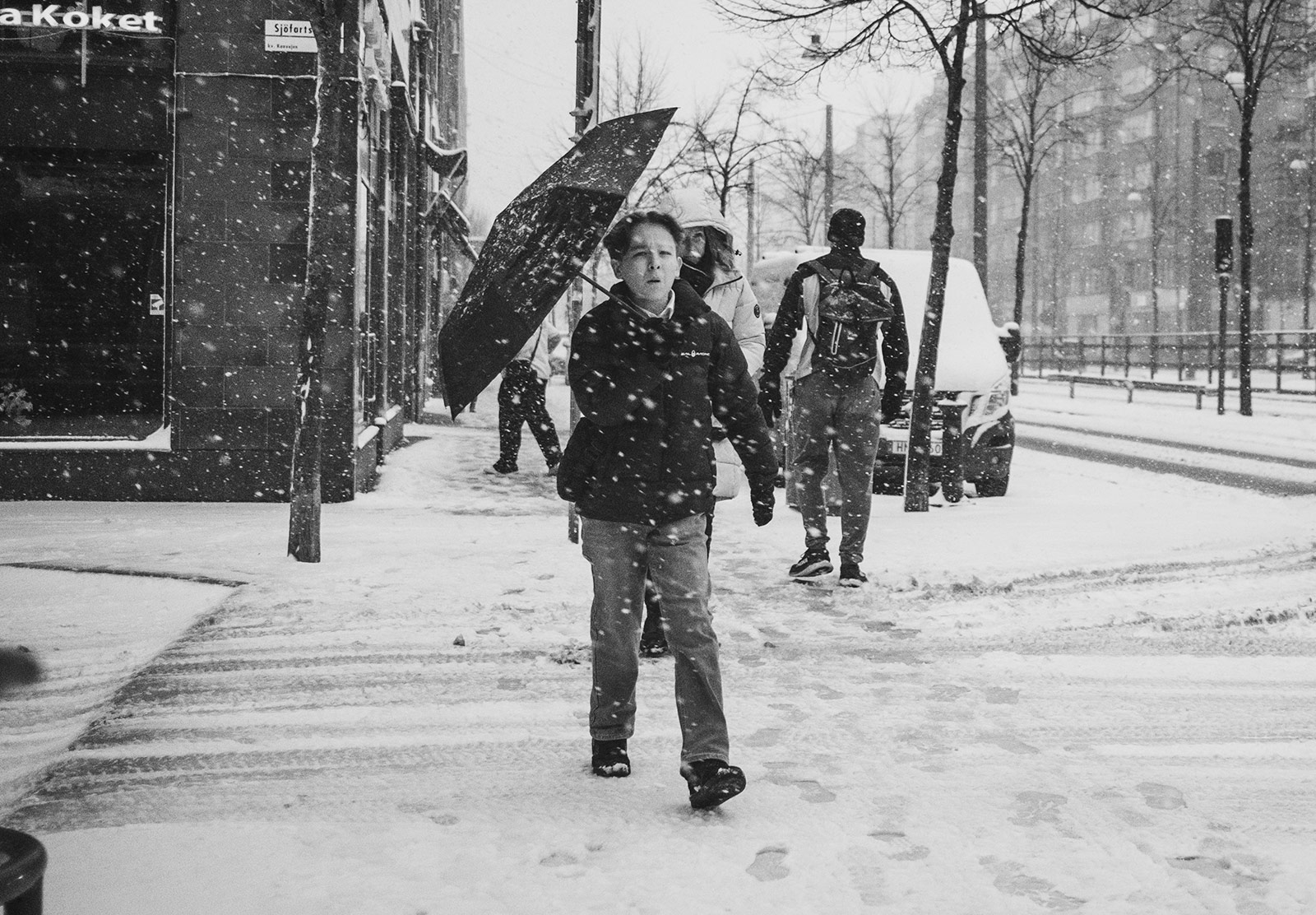 Boy carrying umbrella in the snow