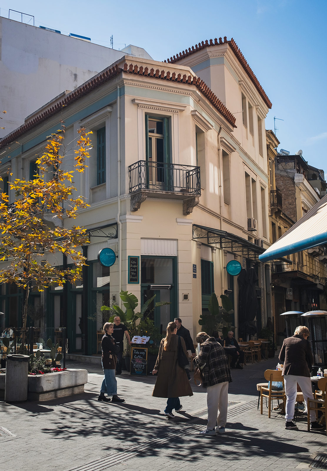 People walking past old building