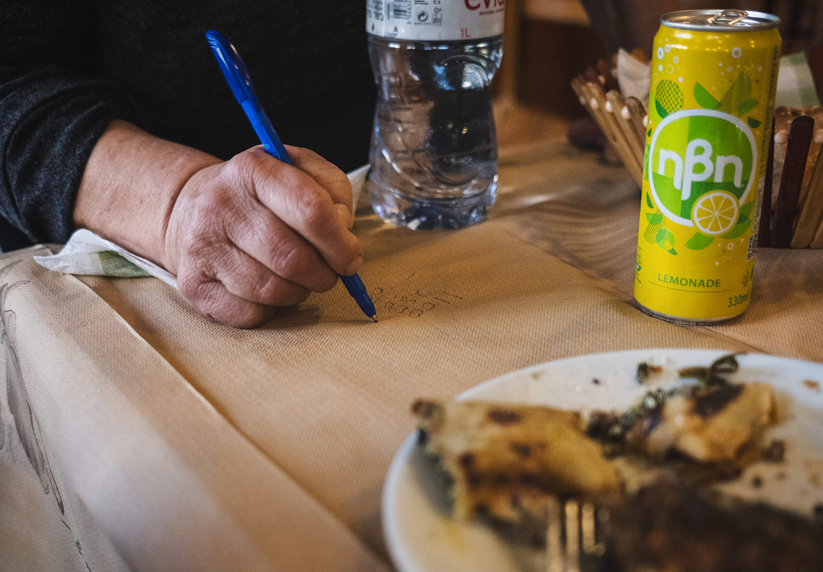 Woman doing maths on paper tablecloth