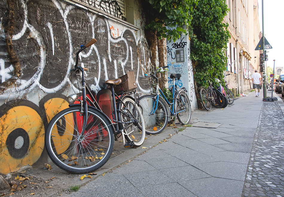Bikes resting against graffiti wall