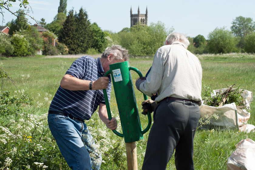 Volunteers securing fence post