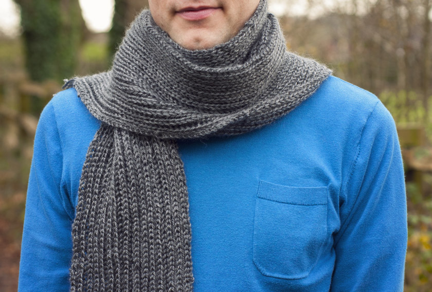Man wearing a knitted grey rib scarf