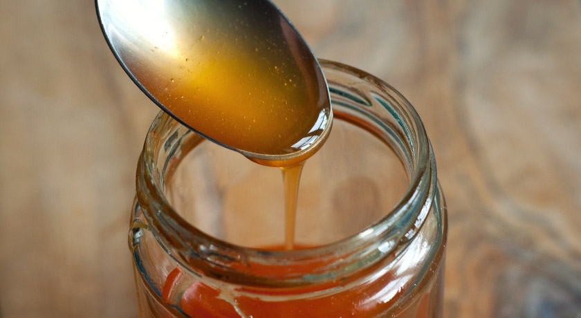 Rosehip syrup dribbling off spoon