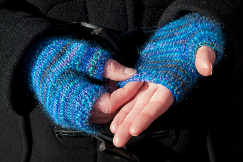 Hands in knitted blue gloves