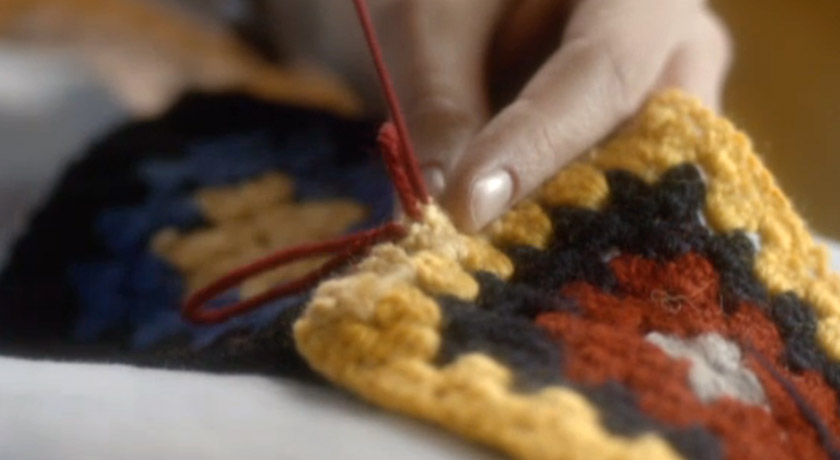 Sewing together granny squares Screenshot of person sewing blanket squares