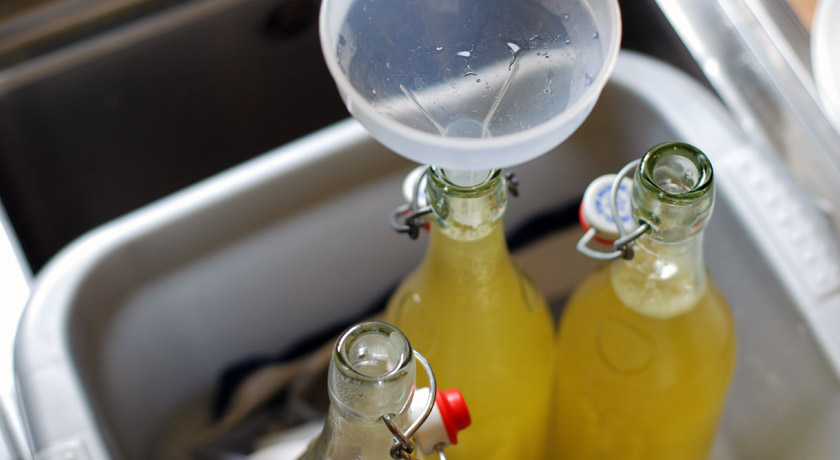 Bottling elderflower cordial with a funnel