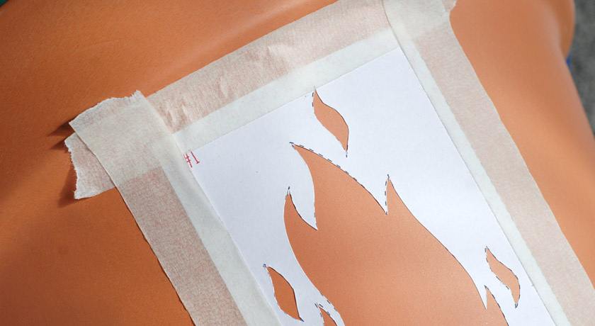 Paper stencil stuck to a pot with masking tape