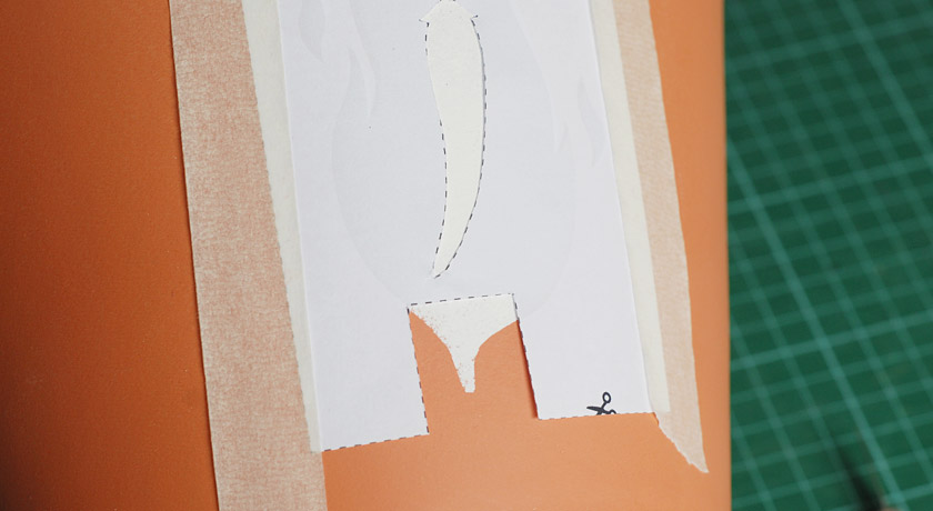 Notch cut out of paper for aligning with stencil underneath