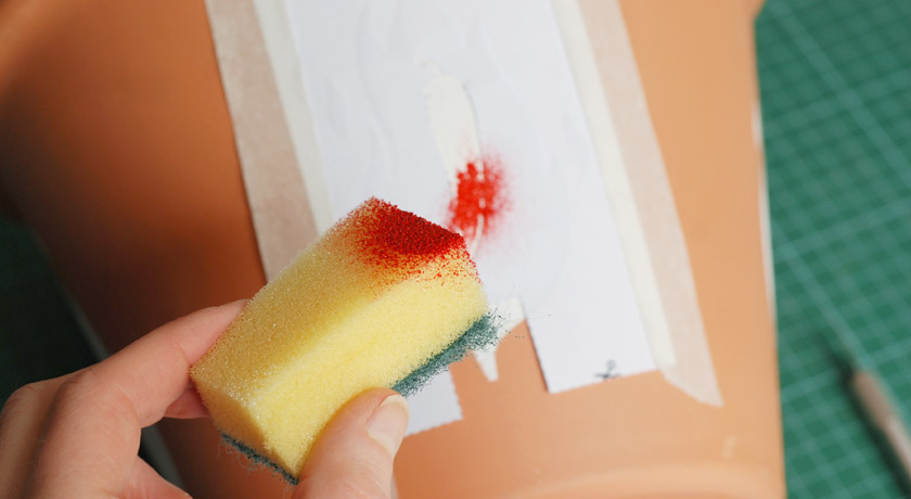 Sponging red paint onto chilli stencil
