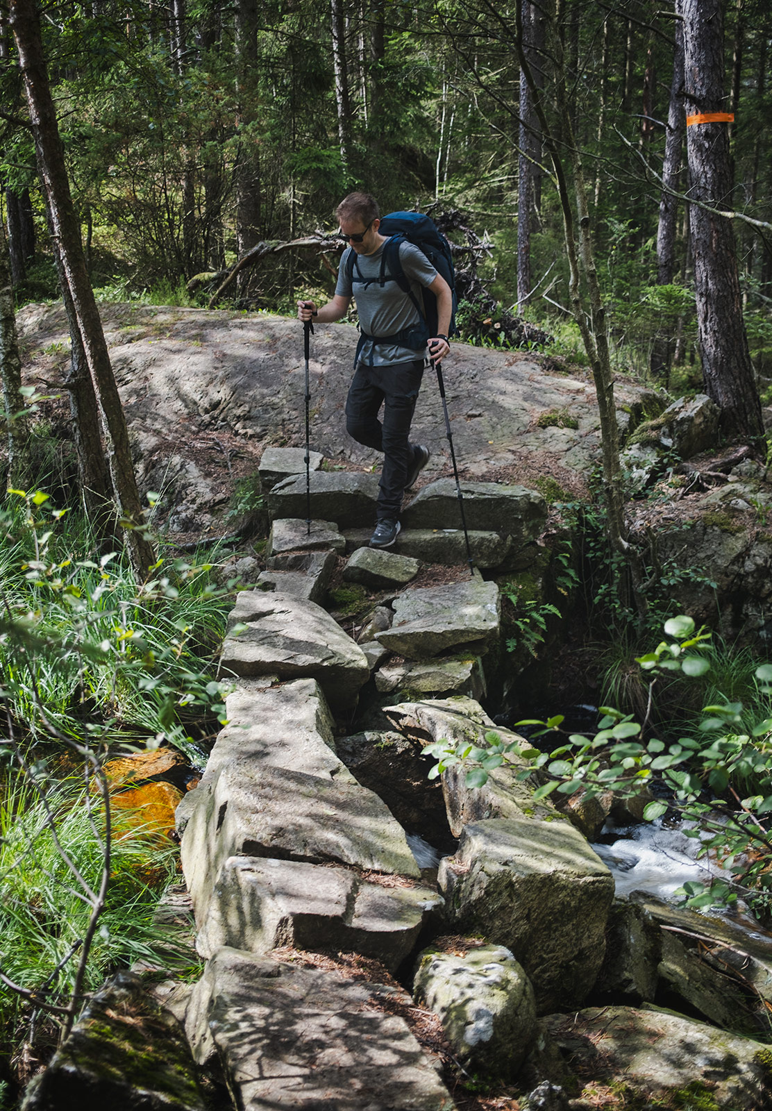 Man walking on stones over stream