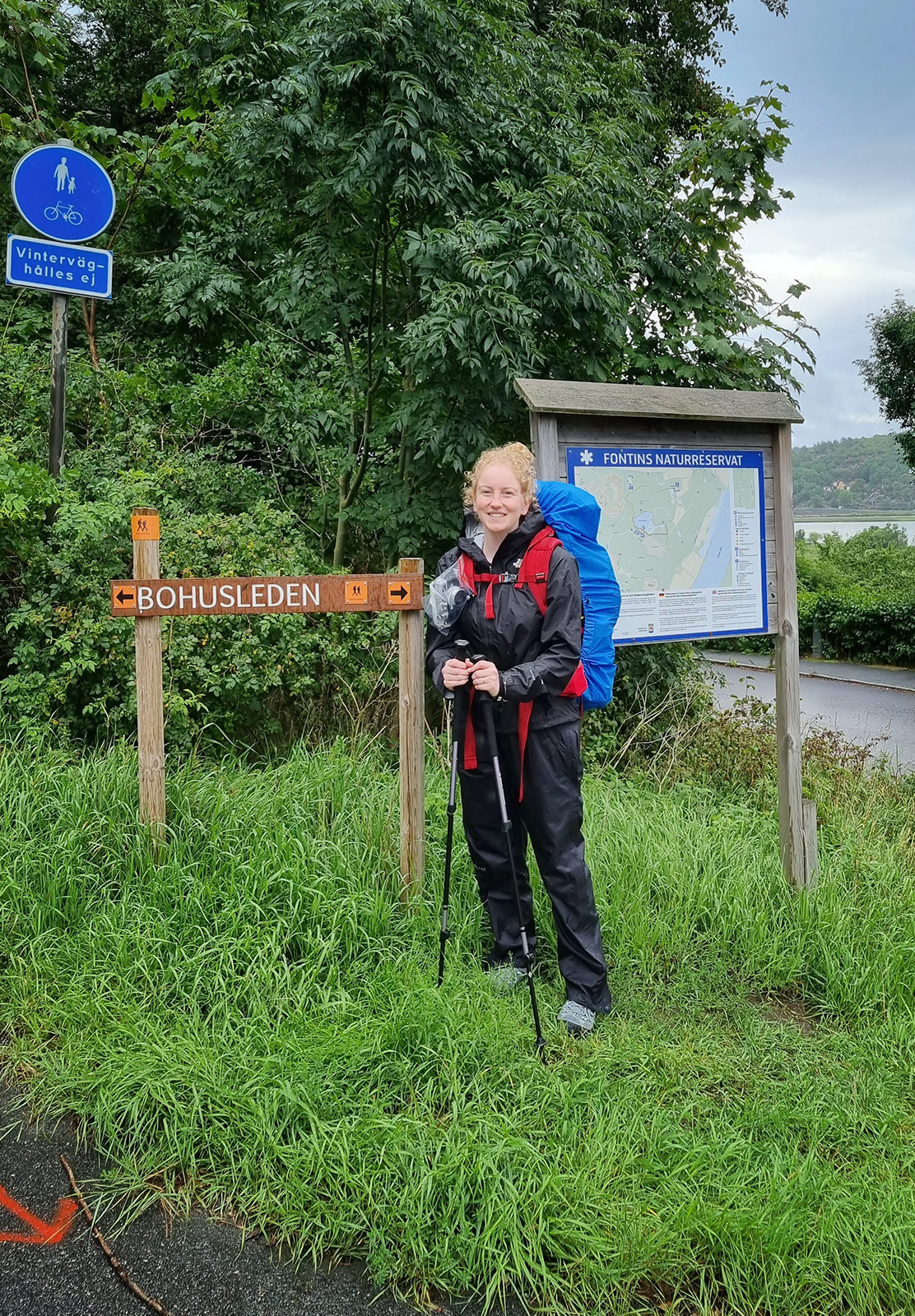 Woman standing next to trail sign