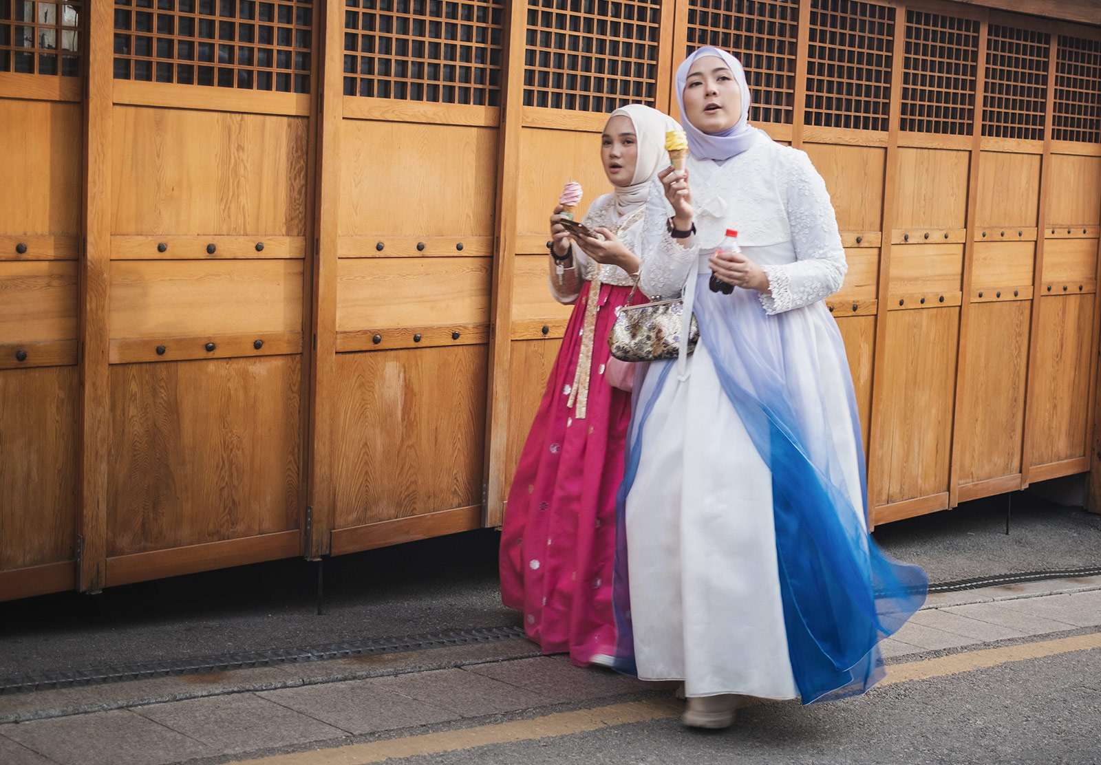 Women in traditional clothes, eating ice-cream