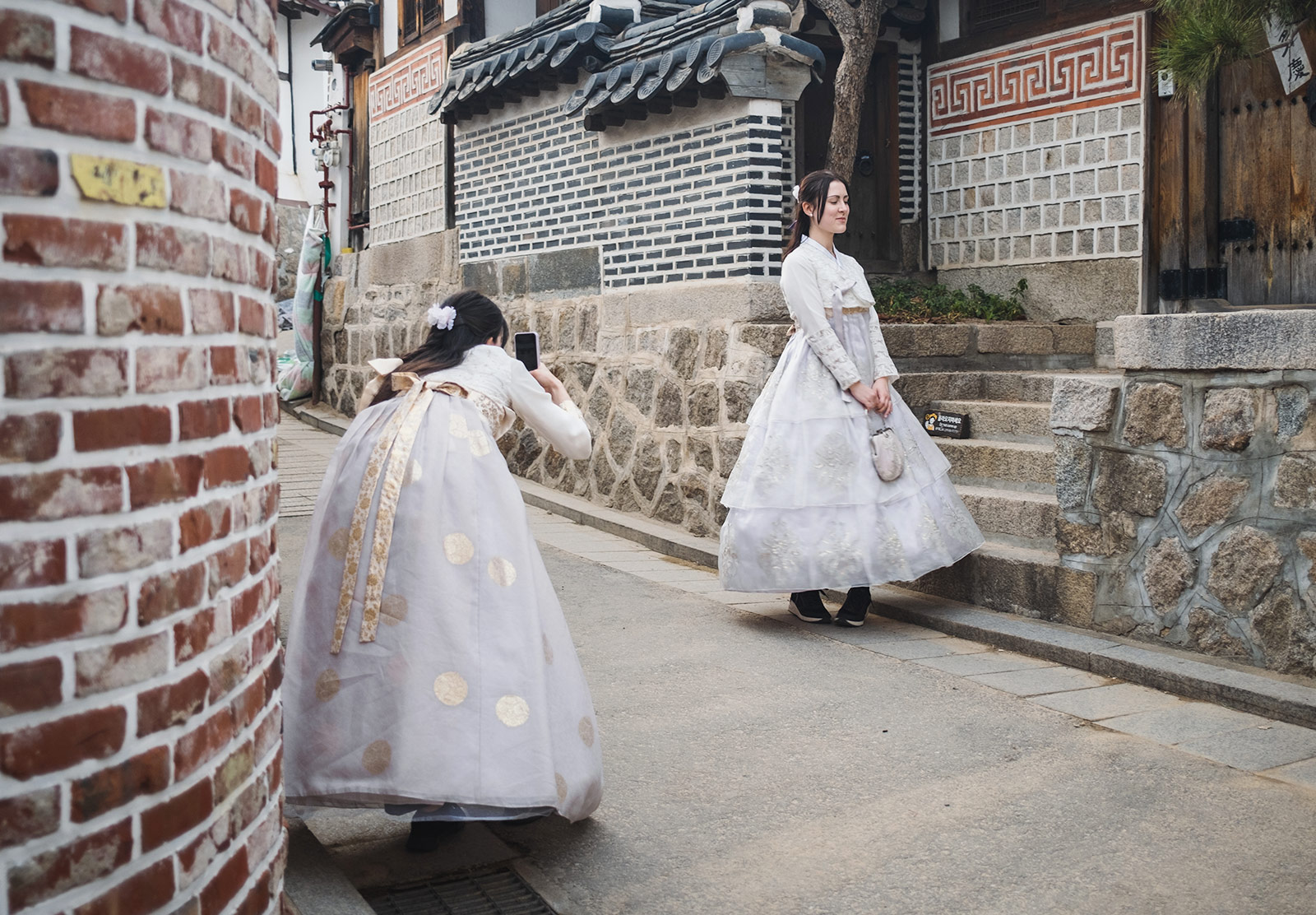 Woman photographing friend in traditional dress