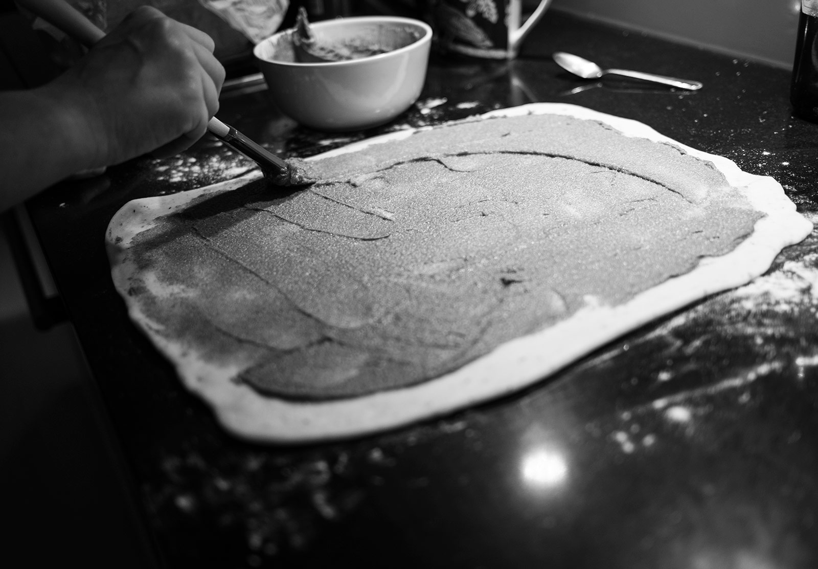 Spreading cinnamon on dough