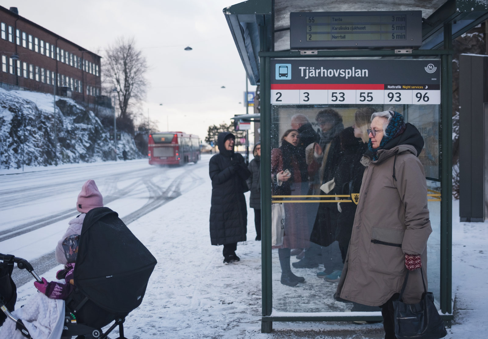 Lady waiting at bus stop in the snow