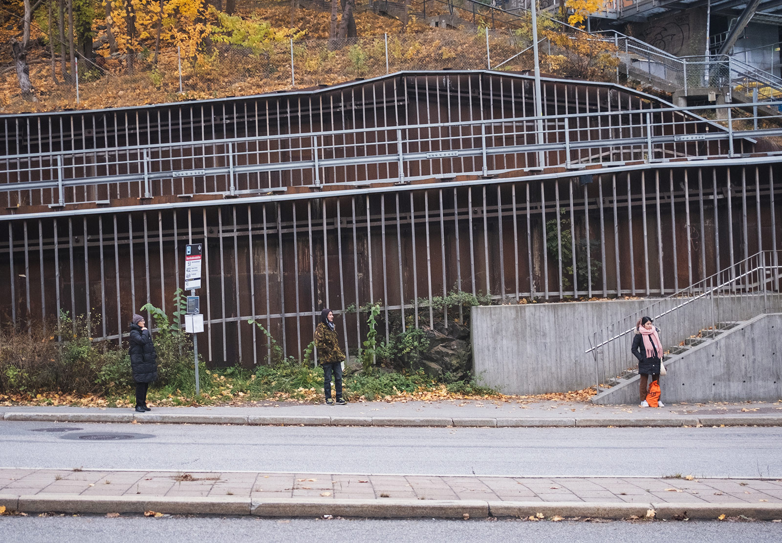 People standing far apart at bus stop