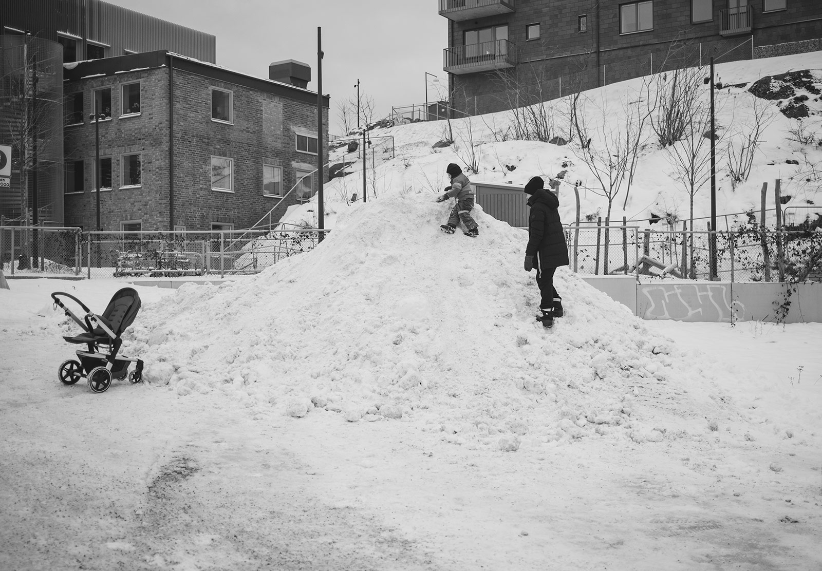 Kid climbing on big snow pile