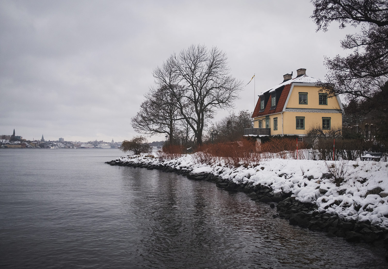 Old house next to snow covered shore