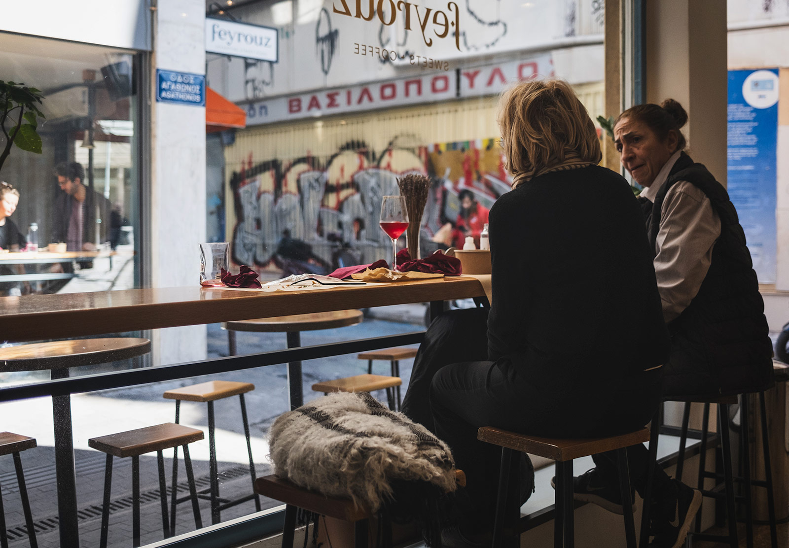 Ladies drinking wine in window seat