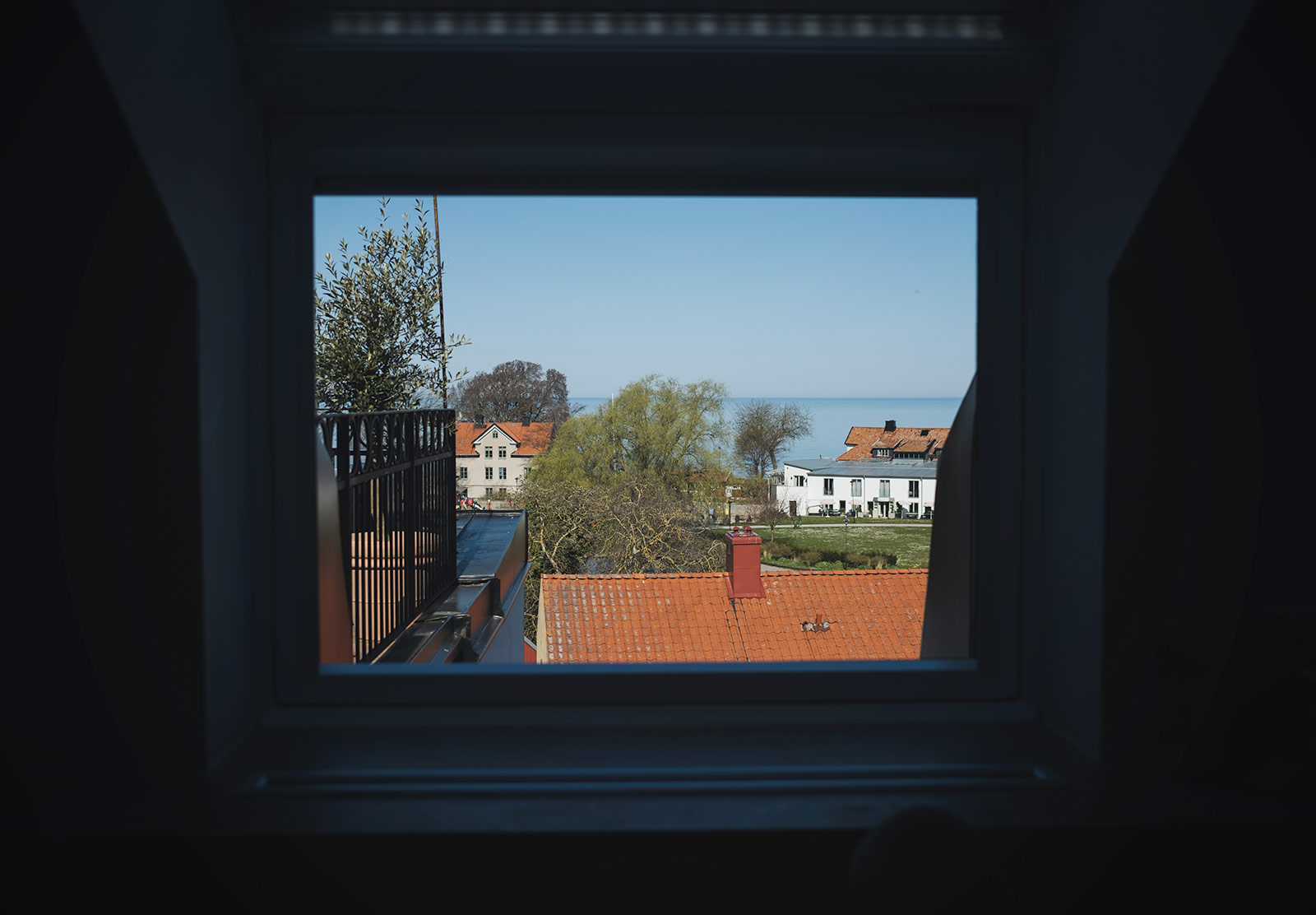Sea and rooftop view through window