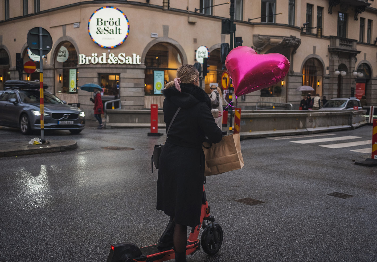 Woman on scooter with heart balloon