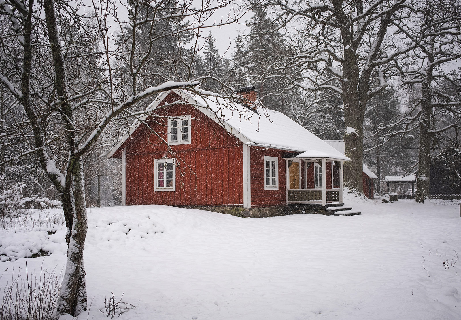 Red wooden house in snow