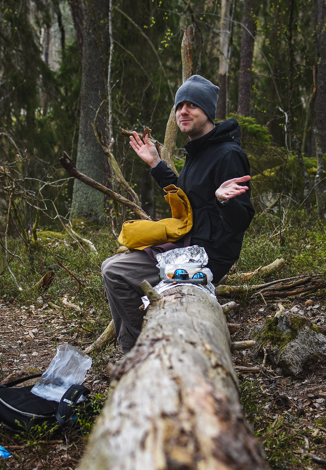 Man eating lunch on log