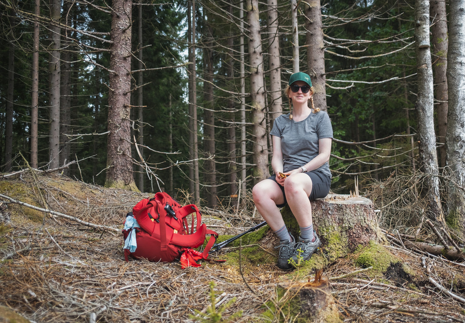 Woman sitting on cut tree stump