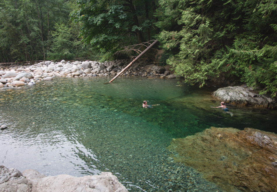 People swimming in natural pool
