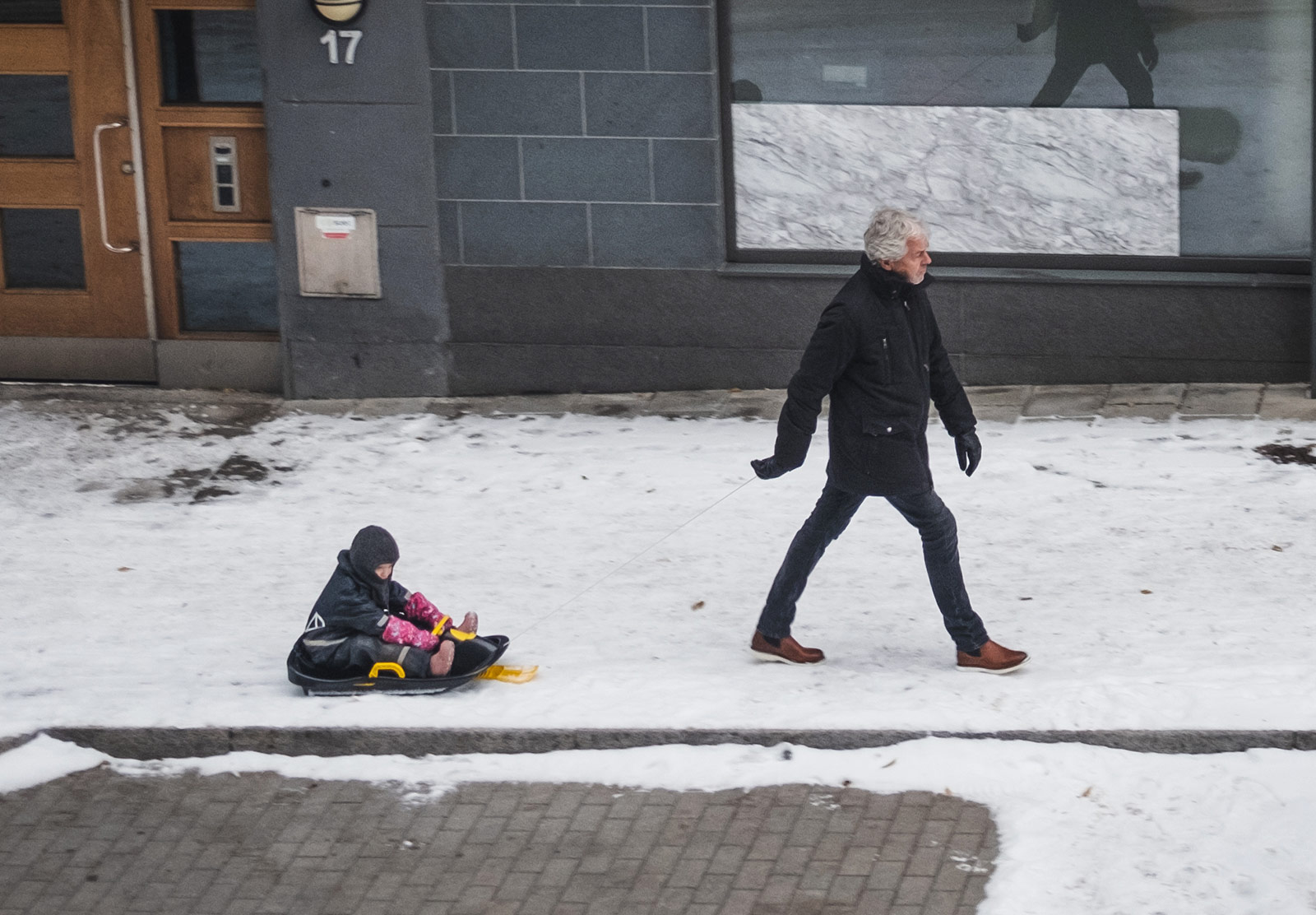 Man pulling child on sledge