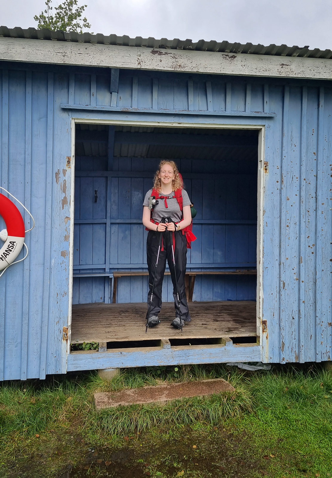 Woman standing inside wooden shelter