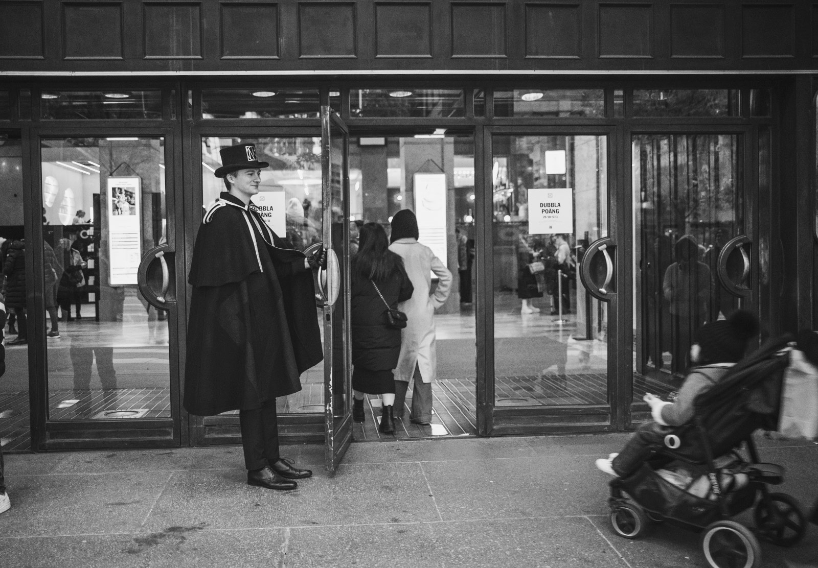 Smartly dressed man holding door open