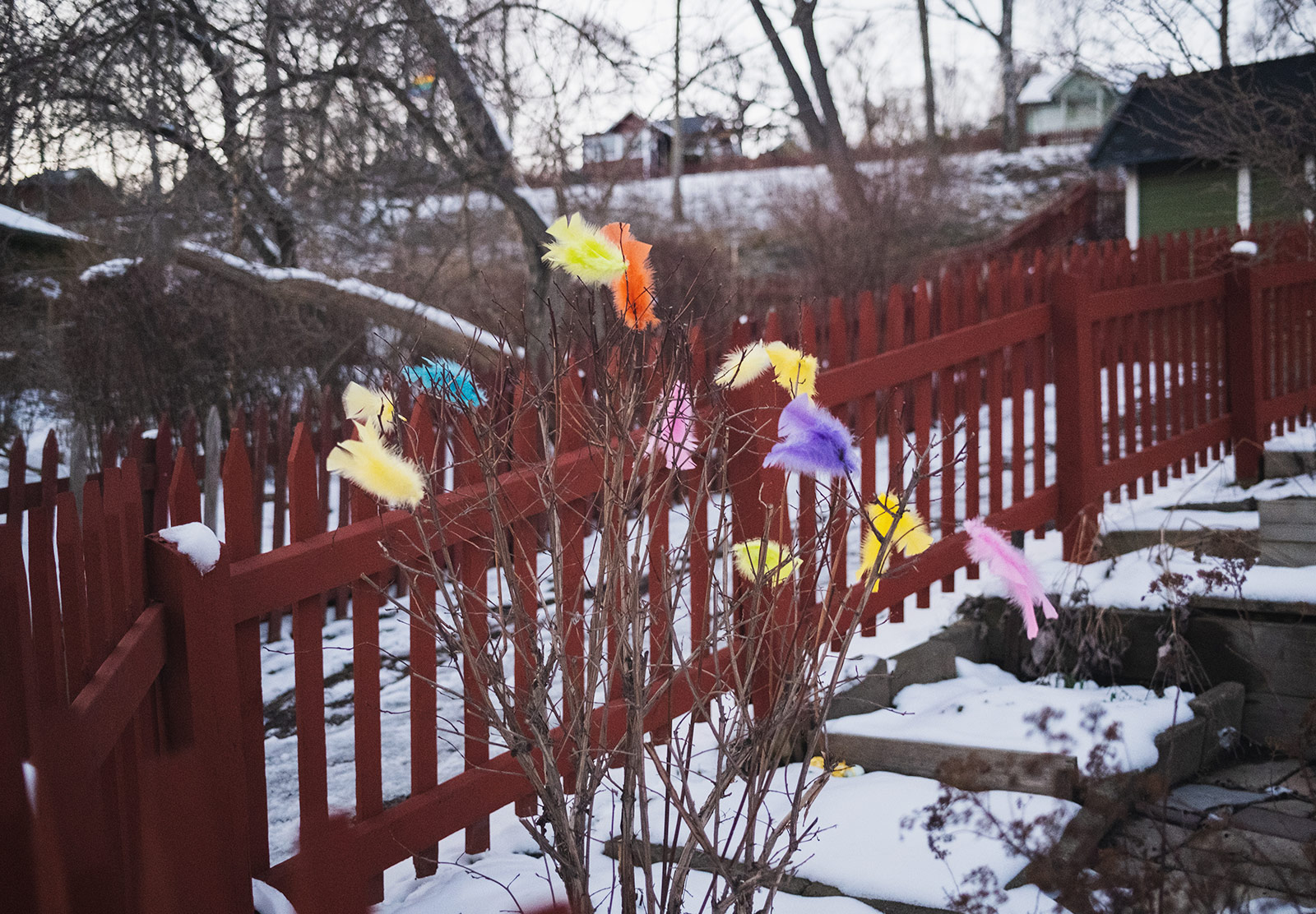 Colourful feathers tied to twigs outdoors