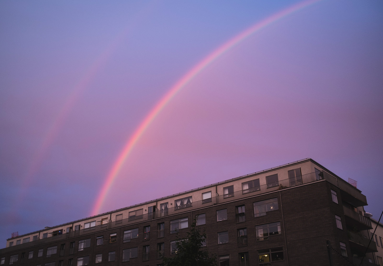 Pink rainbow in blue sky