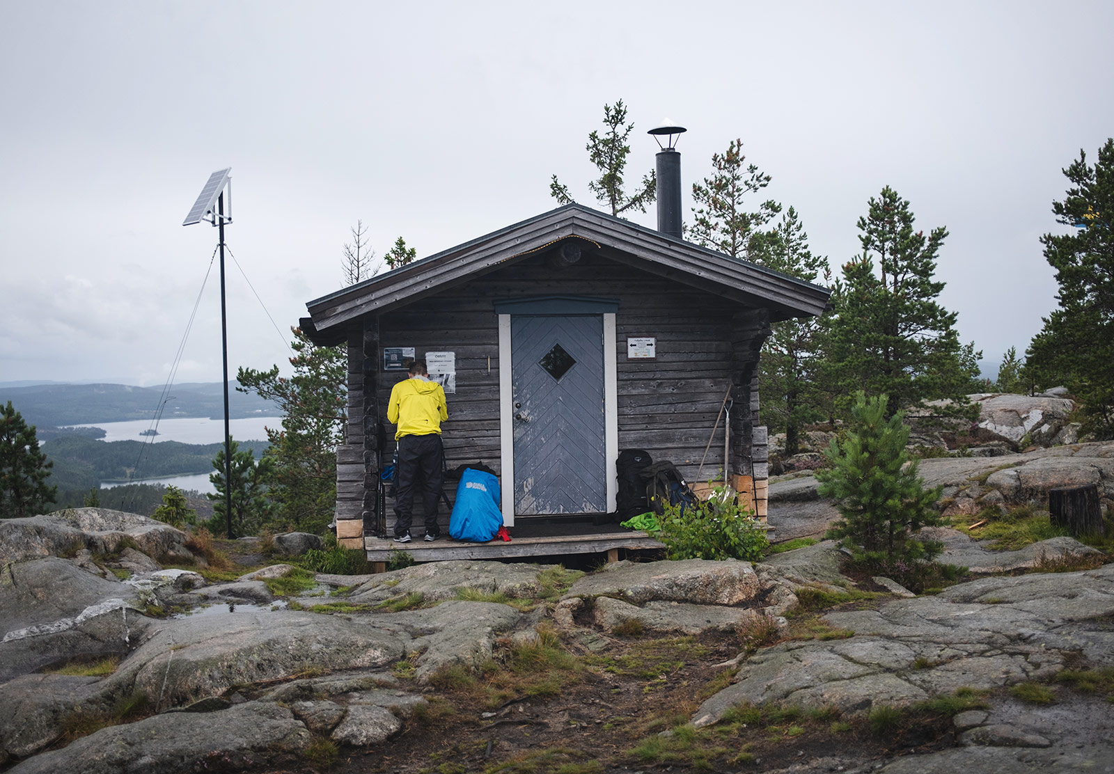 Man stood outside wooden cabin