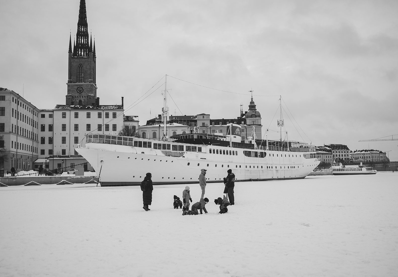 People standing on ice next to boat