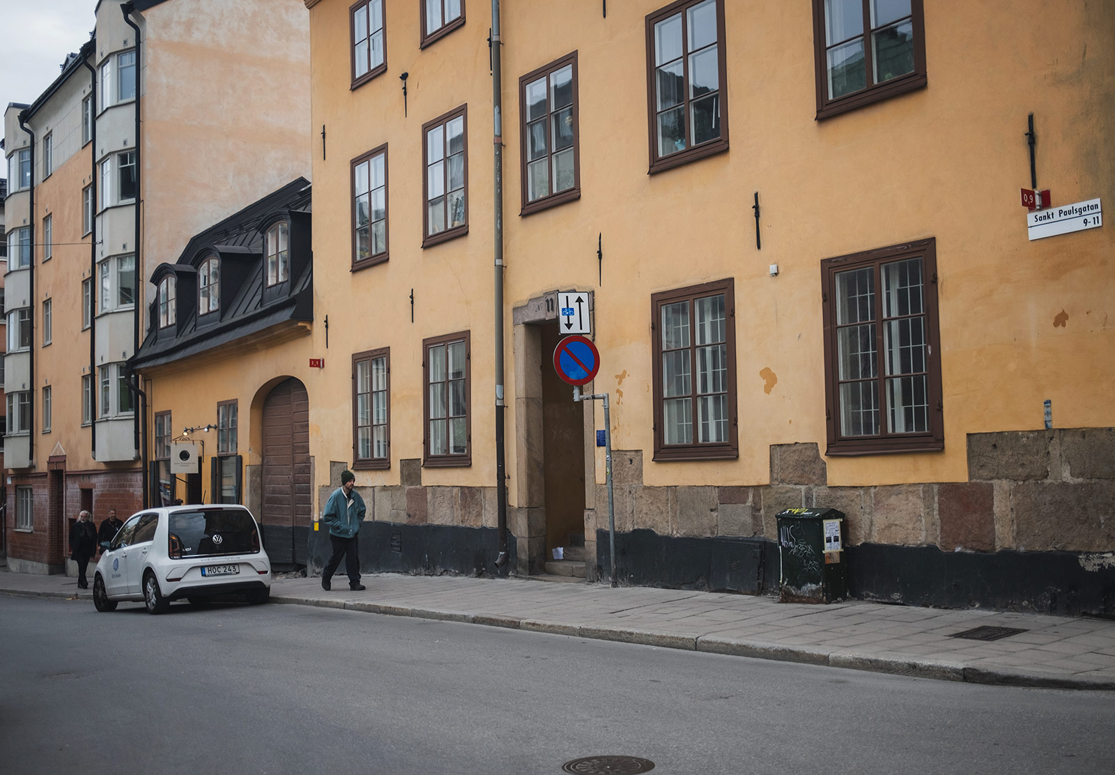 Man walking past old building
