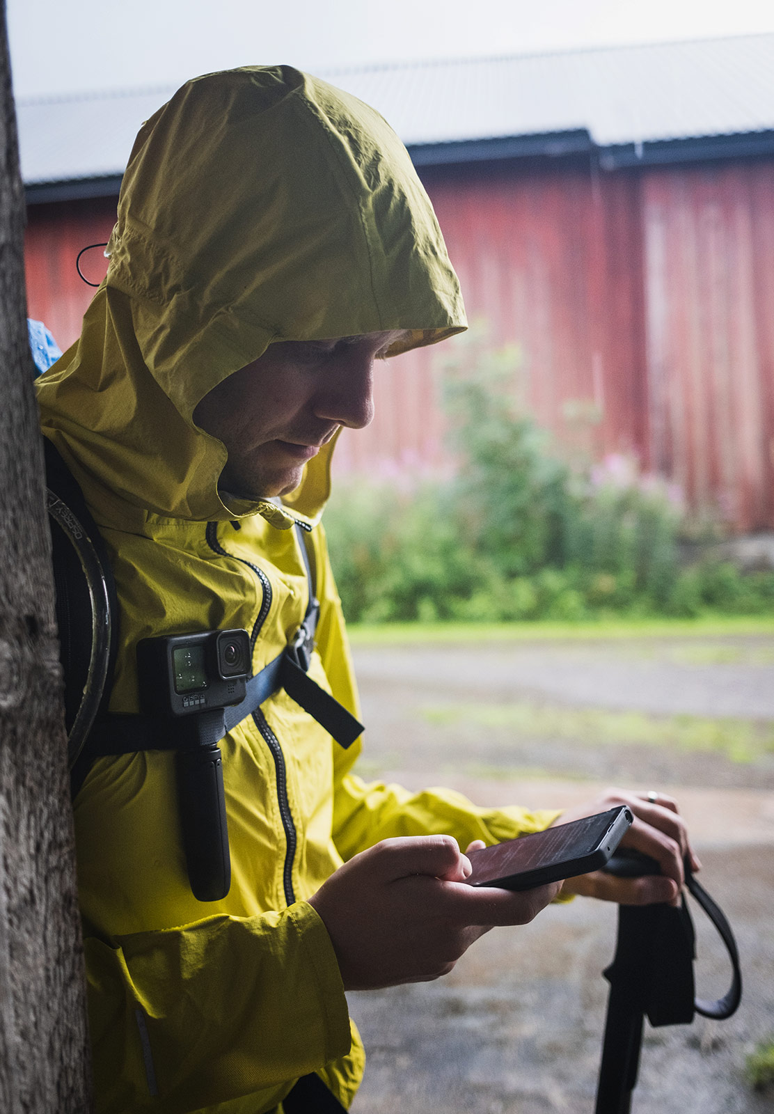 Man on phone, sheltering in a barn