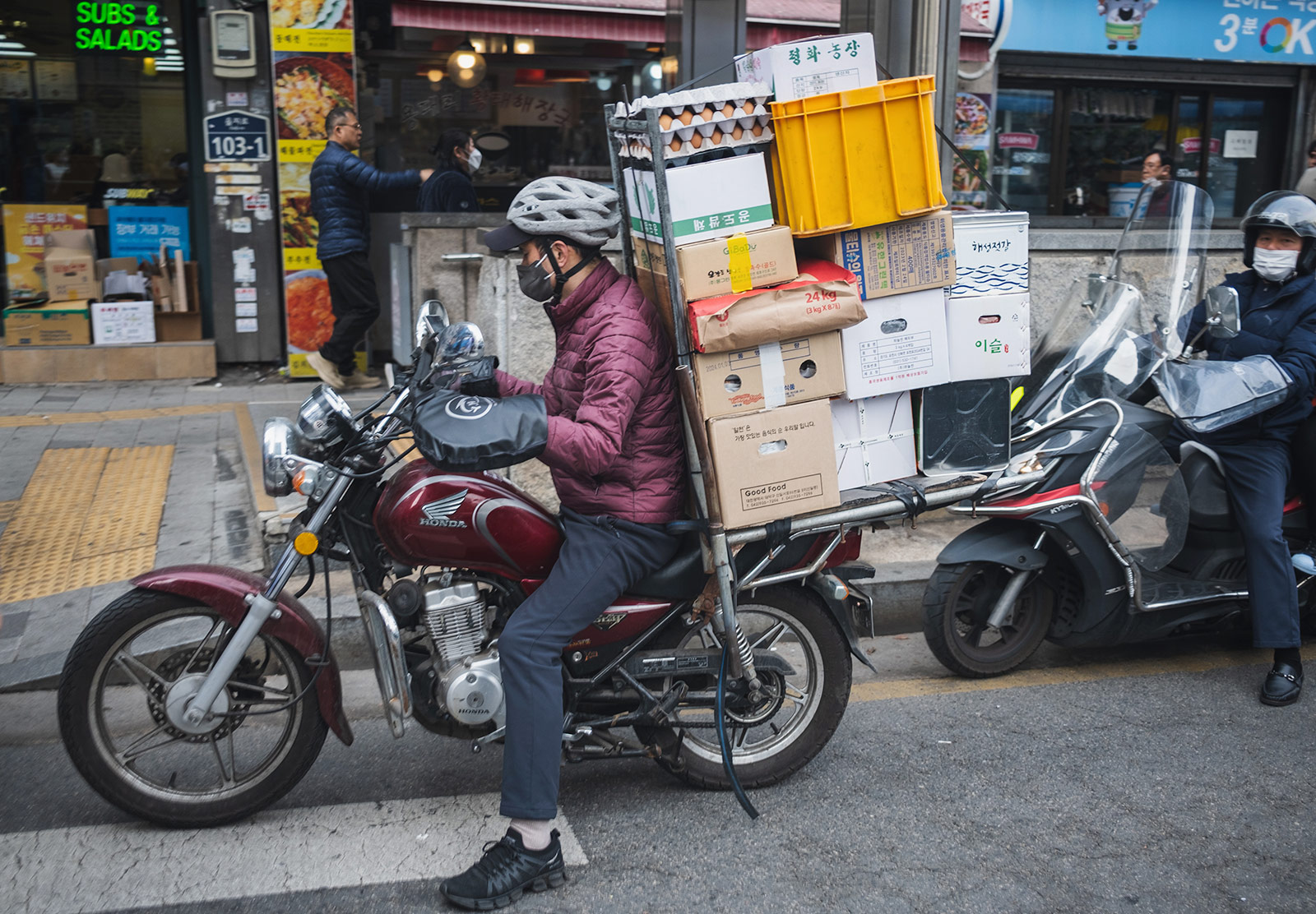 Man with stack of boxes on moped