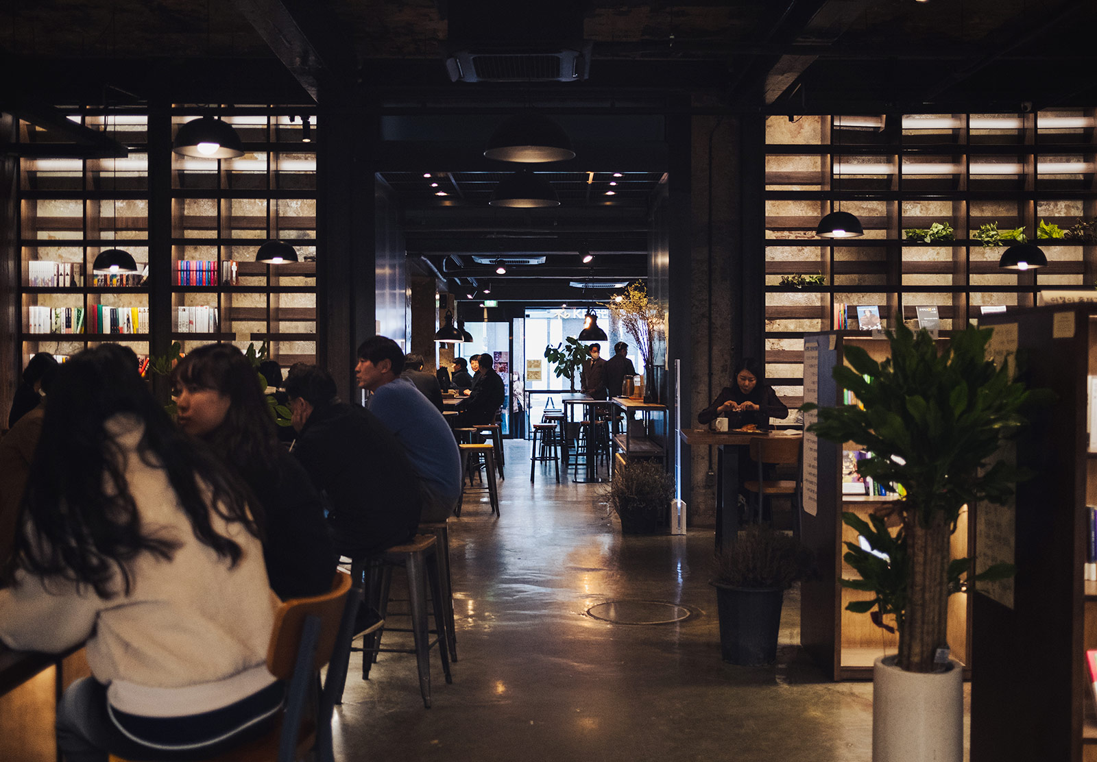 People sat at tables, surrounded by books