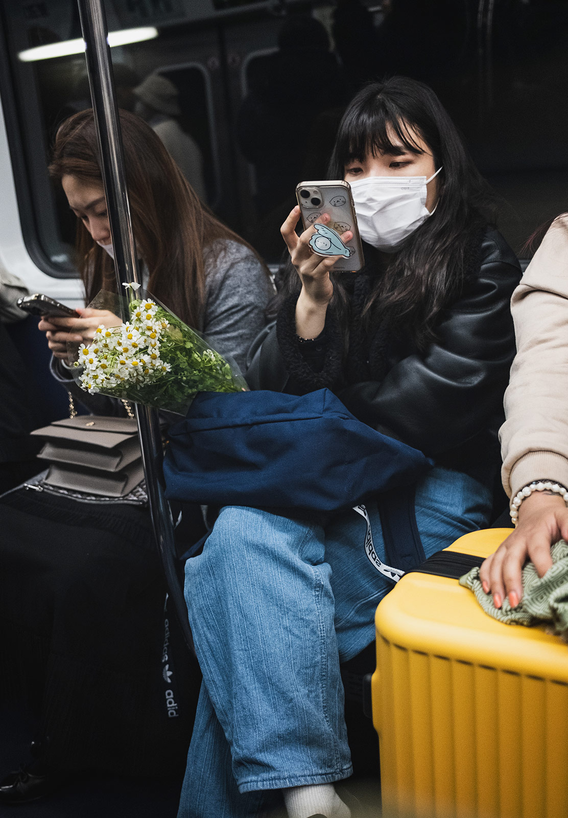 Woman reading phone, with flowers on lap