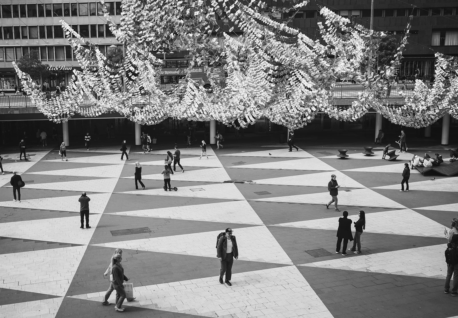 People walking across patterned paving