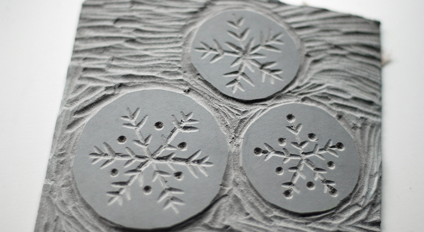 3 snowflakes cut from lino