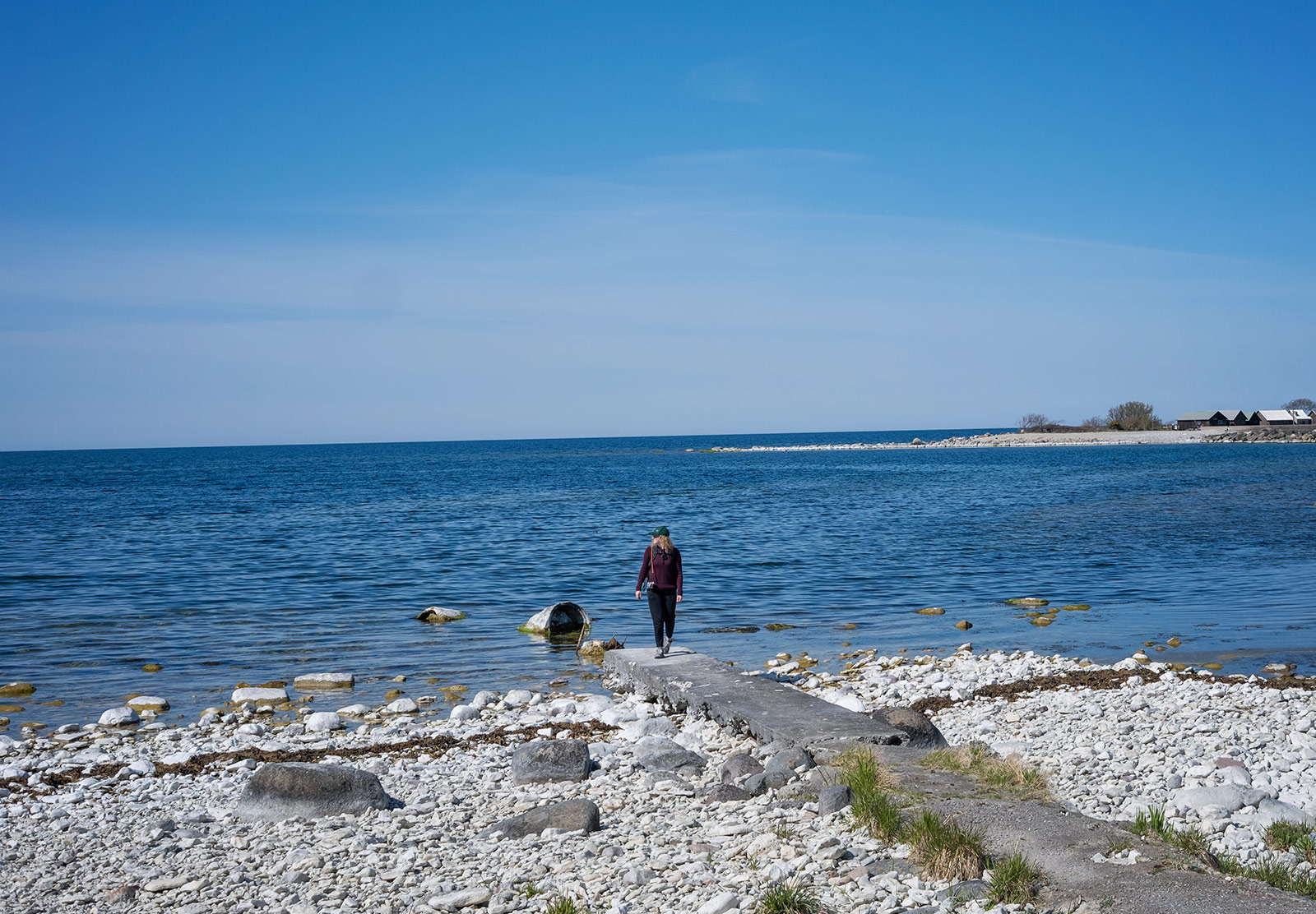 Woman walking along pebble beach