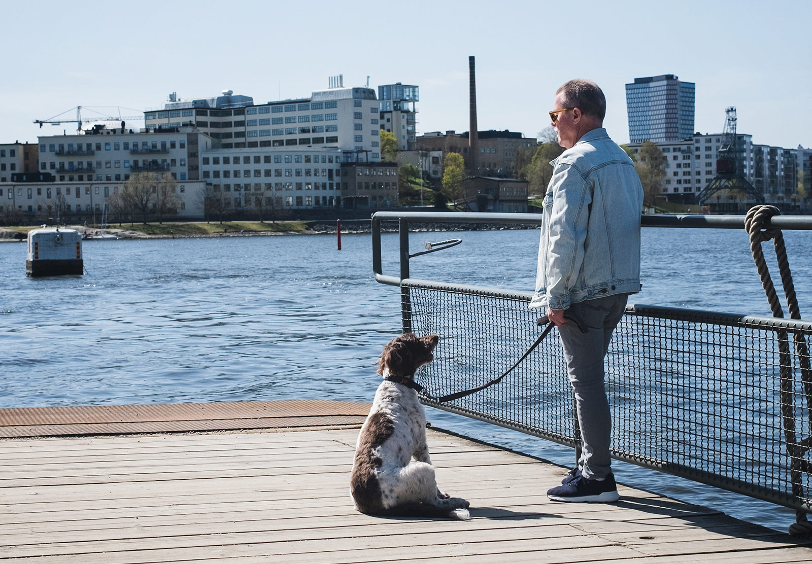 Man stood with dog by the water