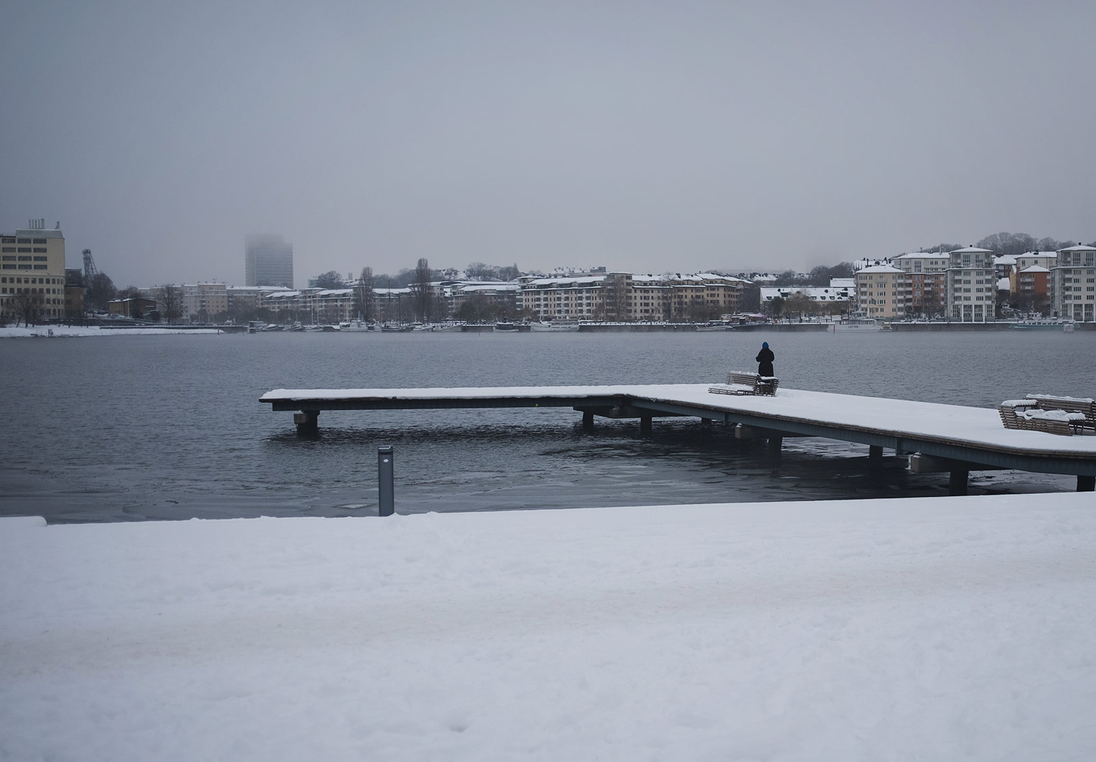 Person standing on snow covered jetty