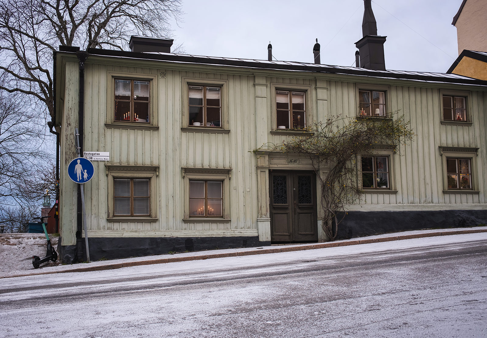 Green wooden house with snow