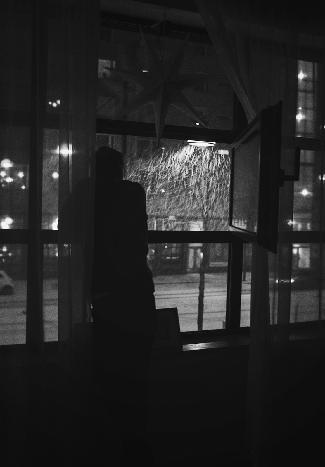 Man watching snow out of a window